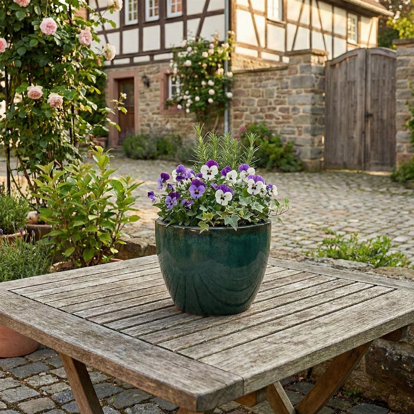 Dunkelgrüne Pflanzkübel Egg Pot im Garten bepflanzt